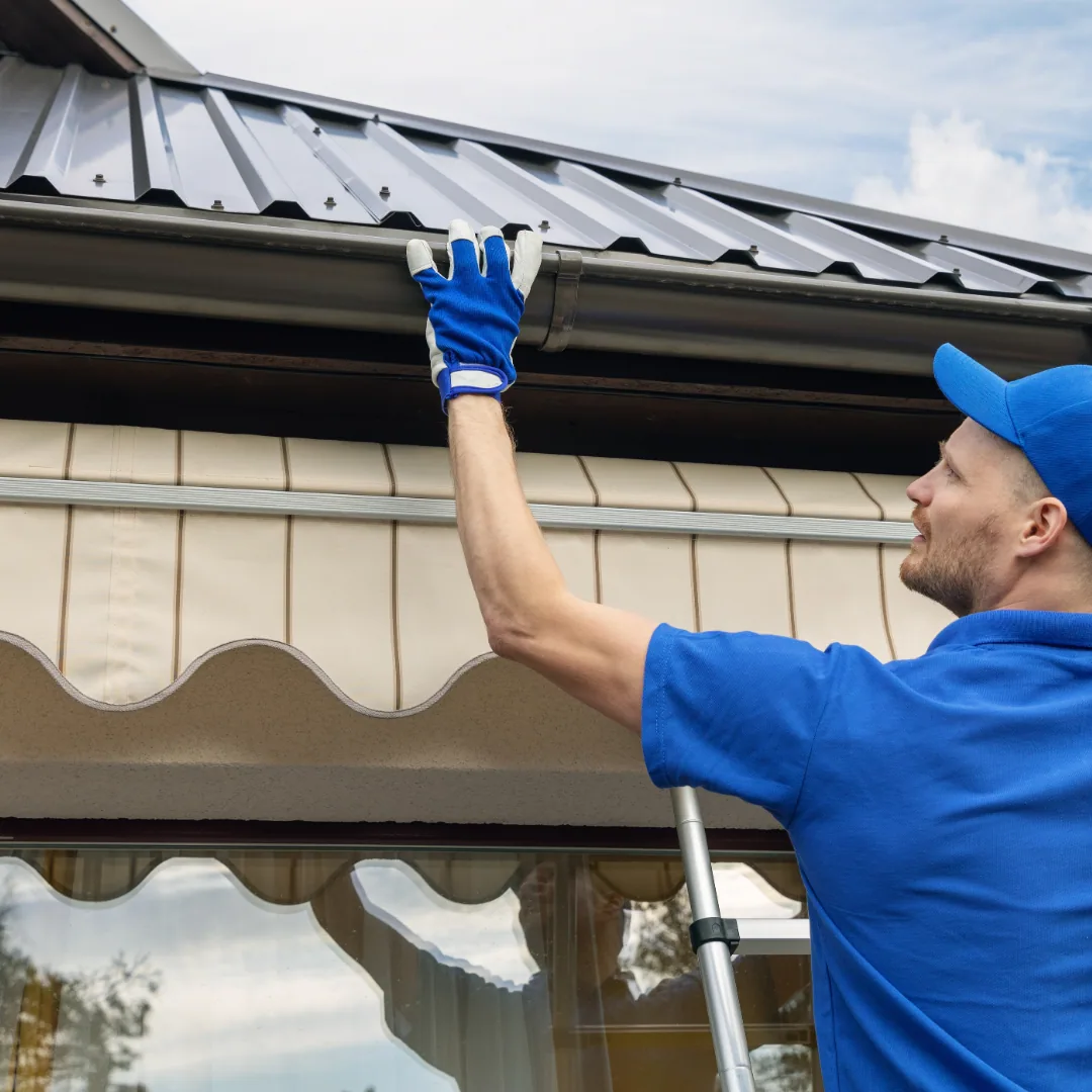 Worker inspecting gutter metal roof, Sanford FL